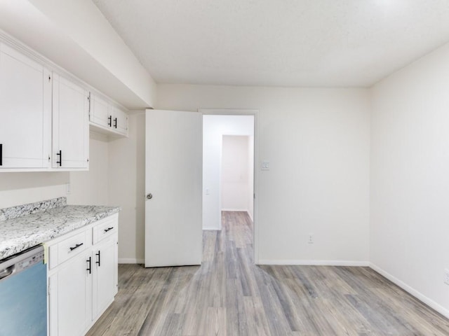 kitchen featuring white cabinetry, dishwasher, light stone counters, and light hardwood / wood-style flooring