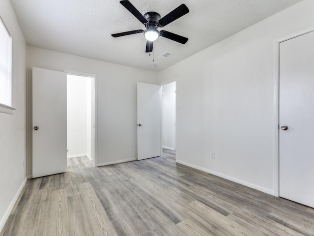 unfurnished bedroom with ceiling fan, a textured ceiling, and light wood-type flooring