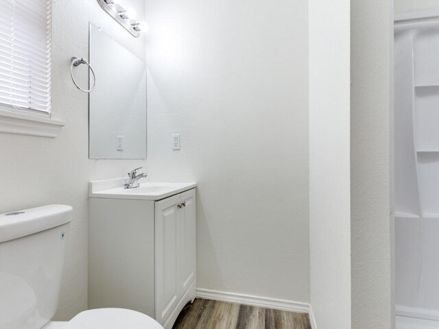 bathroom featuring wood-type flooring, vanity, and toilet