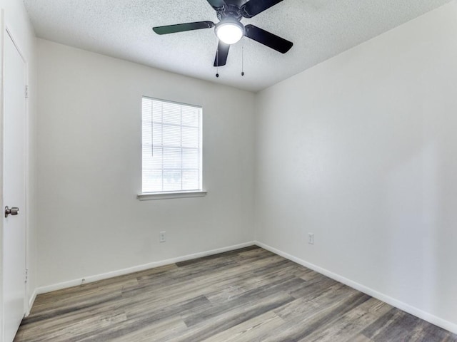 spare room featuring ceiling fan, wood-type flooring, and a textured ceiling