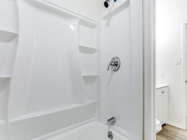 bathroom with bathtub / shower combination, wood-type flooring, and vanity