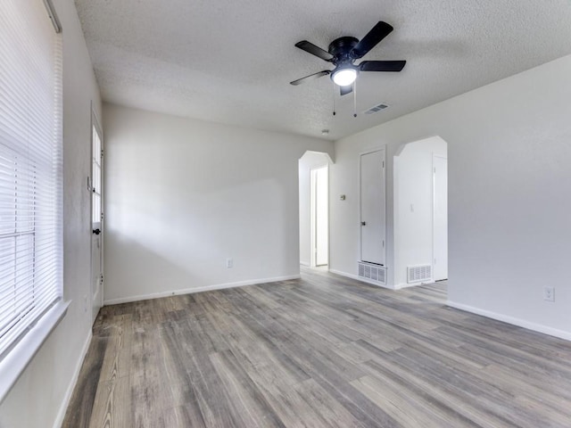 empty room with ceiling fan, a textured ceiling, and hardwood / wood-style flooring