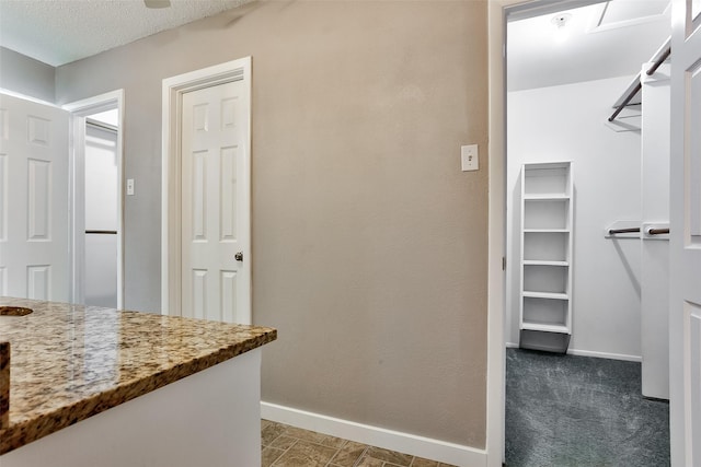 interior space with stone counters and dark carpet