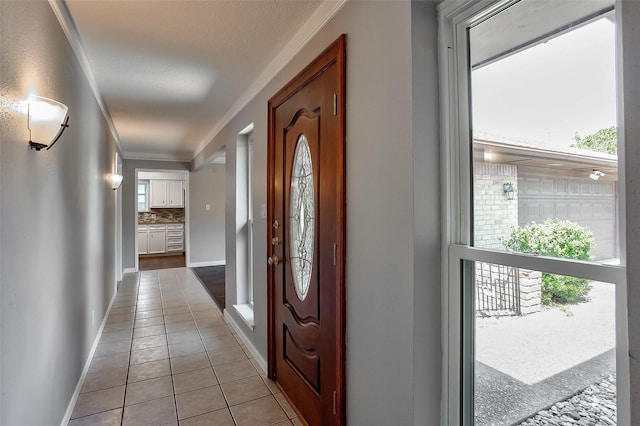 tiled entryway featuring ornamental molding