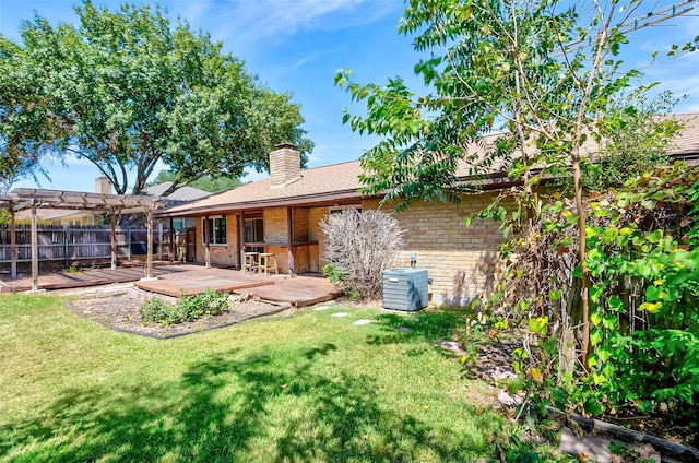 back of property featuring a yard, a pergola, and a deck