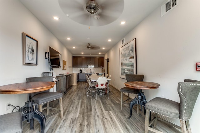 dining room with ceiling fan and light hardwood / wood-style floors