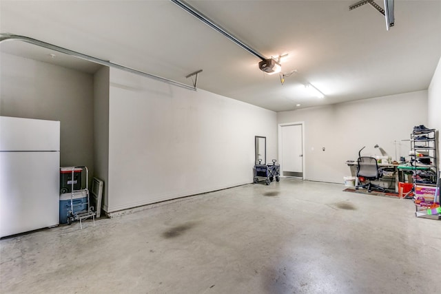 garage with a garage door opener and white fridge