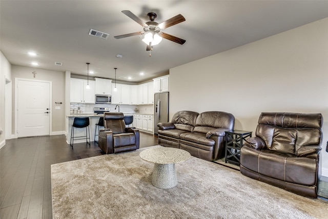 living room featuring dark hardwood / wood-style floors and ceiling fan