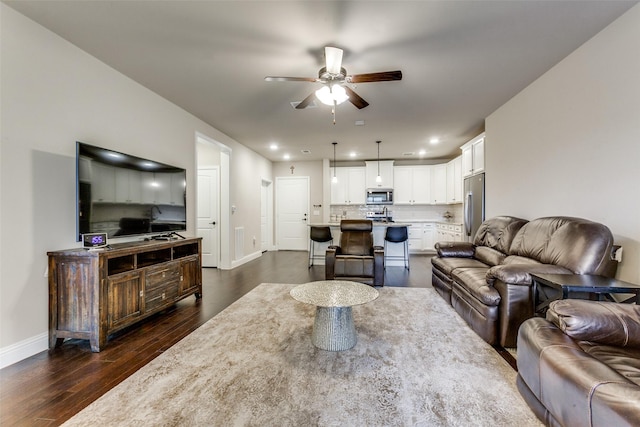 living room with ceiling fan and dark wood-type flooring