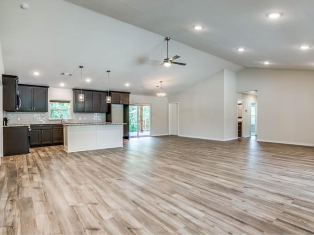 kitchen with light hardwood / wood-style floors, ceiling fan, backsplash, decorative light fixtures, and lofted ceiling