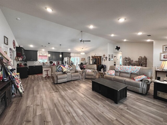 living room featuring lofted ceiling, hardwood / wood-style floors, and ceiling fan