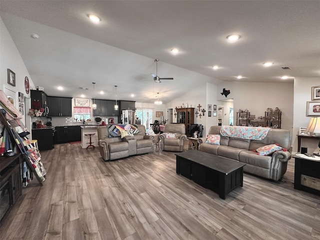 living room with lofted ceiling, wood-type flooring, and ceiling fan