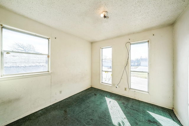 carpeted empty room with a textured ceiling