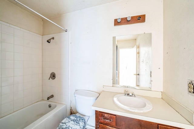 full bathroom with toilet, tiled shower / bath combo, a textured ceiling, and vanity