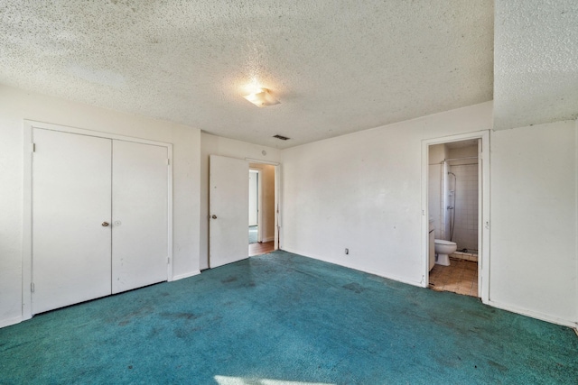 unfurnished bedroom with a textured ceiling, connected bathroom, a closet, and carpet