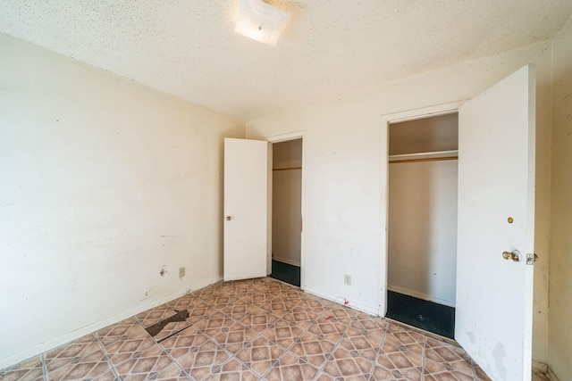 unfurnished bedroom featuring a textured ceiling and a closet