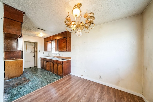 kitchen featuring a textured ceiling, hardwood / wood-style floors, and a notable chandelier