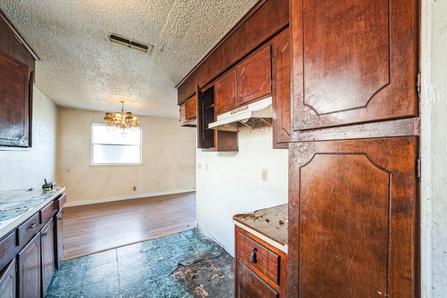 kitchen with a textured ceiling and an inviting chandelier