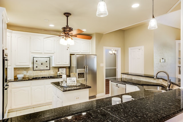 kitchen with white cabinets, stainless steel appliances, decorative backsplash, sink, and hanging light fixtures