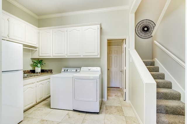 washroom featuring cabinet space, crown molding, and independent washer and dryer