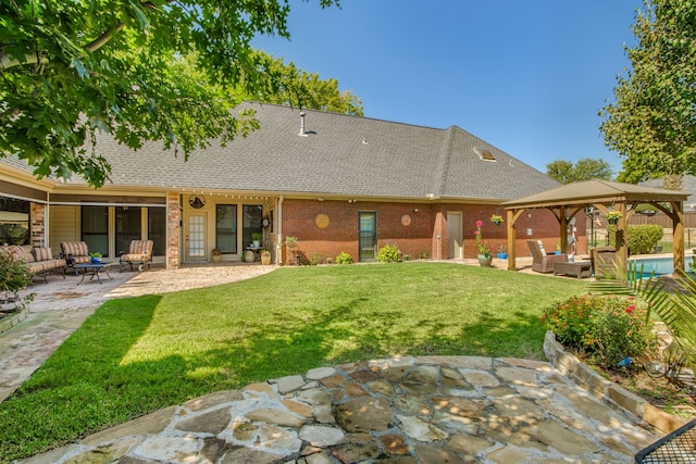 back of property featuring a patio, roof with shingles, a gazebo, a lawn, and brick siding