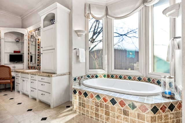 bathroom with a relaxing tiled tub, ornamental molding, and vanity