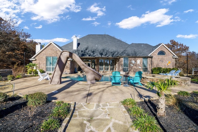 rear view of property with a patio area and a pool