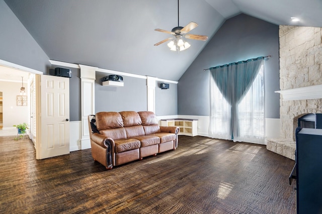 living room featuring a fireplace, vaulted ceiling, ceiling fan, and dark wood-type flooring