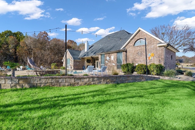 back of property featuring a patio area and a lawn