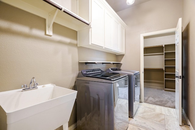 washroom featuring cabinets, sink, and washing machine and clothes dryer