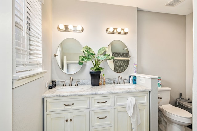 bathroom with vanity, toilet, and a bidet