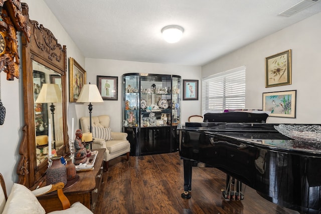 miscellaneous room featuring a textured ceiling and dark wood-type flooring