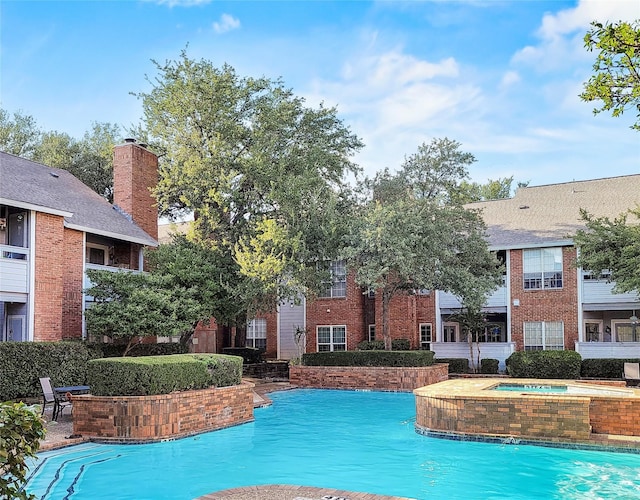 view of swimming pool with a hot tub