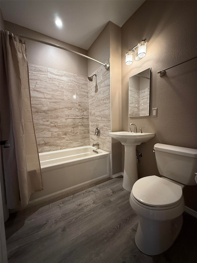 bathroom with wood-type flooring, toilet, and shower / bath combo with shower curtain