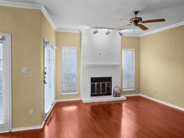 unfurnished living room with a fireplace, ceiling fan, a textured ceiling, and crown molding