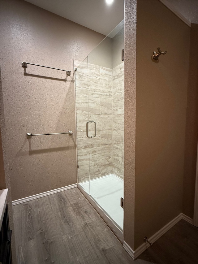 bathroom featuring hardwood / wood-style flooring and walk in shower