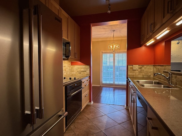 kitchen with sink, crown molding, light tile patterned floors, hanging light fixtures, and black appliances