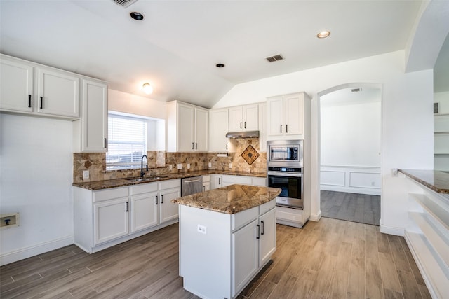 kitchen featuring stainless steel appliances, white cabinets, and dark stone counters