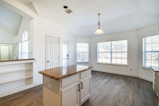 kitchen with white cabinetry, light stone counters, a center island, hanging light fixtures, and dark hardwood / wood-style floors