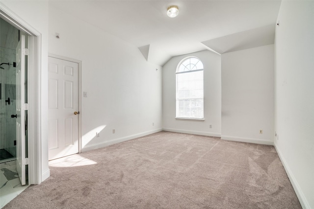 unfurnished room with light carpet and vaulted ceiling