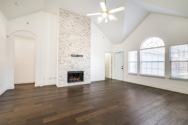 unfurnished living room with dark hardwood / wood-style flooring, high vaulted ceiling, ceiling fan, and a fireplace