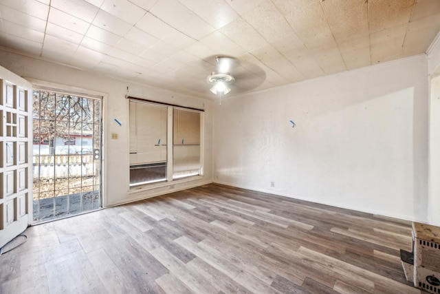 empty room featuring crown molding, hardwood / wood-style flooring, and ceiling fan