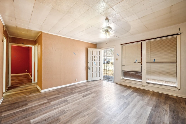 empty room with ceiling fan, ornamental molding, and hardwood / wood-style floors