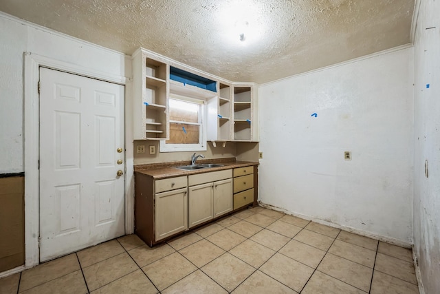 kitchen with sink, a textured ceiling, and light tile patterned floors