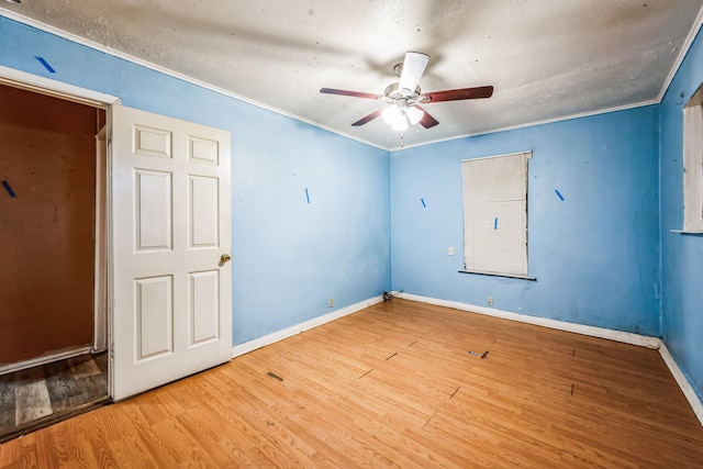 unfurnished room with crown molding, ceiling fan, wood-type flooring, and a textured ceiling