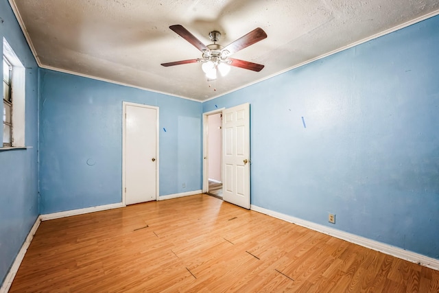 unfurnished bedroom featuring crown molding, hardwood / wood-style floors, a textured ceiling, and ceiling fan