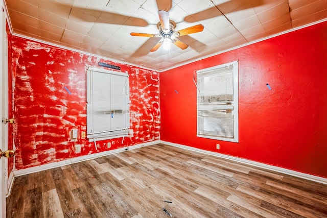 spare room with hardwood / wood-style floors, crown molding, and ceiling fan