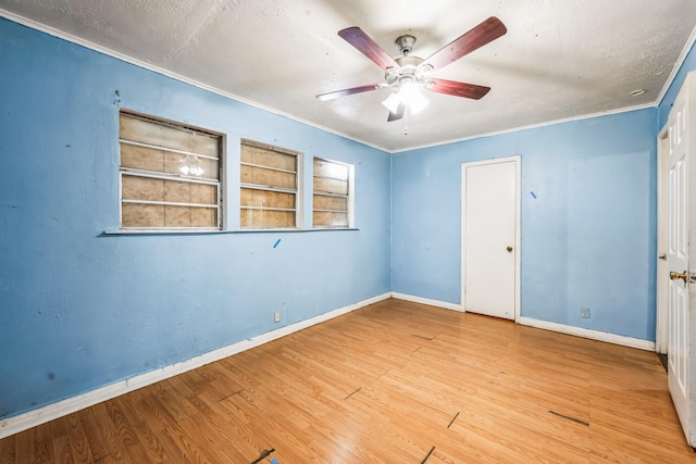 unfurnished bedroom featuring crown molding, wood-type flooring, a textured ceiling, a closet, and ceiling fan