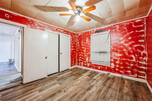 unfurnished bedroom featuring hardwood / wood-style flooring, ceiling fan, and a closet