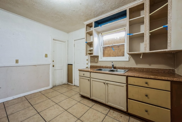 kitchen with sink, light tile patterned floors, and a textured ceiling